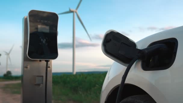 利用风力涡轮机提供绿色和可再生能源的充电站为电动汽车充电 以保护环境 — 图库视频影像