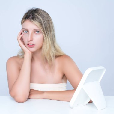 Güzel bir kadının çekici portresi cildinde, yağlı ya da sivilceli bir şekilde kendini güvensiz hisseder. Kusursuz pürüzsüz cilde sahip endişeli bir kadın model. Yüzünü izole edilmiş arka plandaki aynada kontrol et..