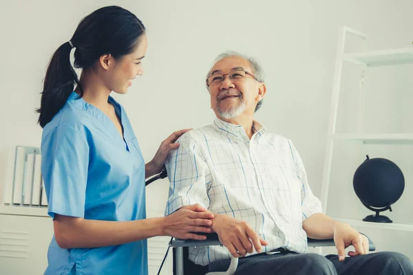 Happy Positive Asian Nurse Giving Support Touching Contented Senior Man — Stok fotoğraf