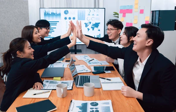 Happy business team office worker making high five with each other and celebrate after successful meeting in office workplace, business agreement to promote harmony and strong teamwork concept.