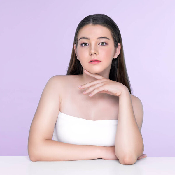 Портрет юной брюнетки с длинными волосами и безупречной кожей с жестом руки для красоты и косметической концепции. очаровательная красивая молодая девушка позирует руки для кожи или косметической рекламы.