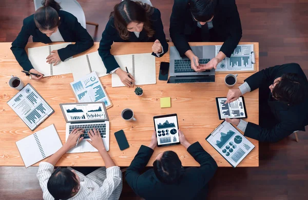 Top-view business team of financial data analysis meeting with business intelligence, report paper and dashboard on laptop for marketing strategy. Business people working together in office of harmony
