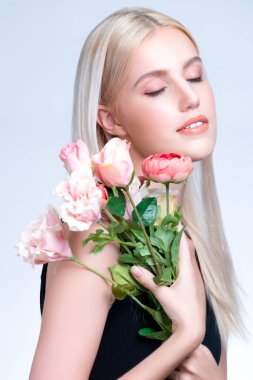 Closeup young personable woman with natural makeup and healthy soft skin holding rose for beauty care advertising in isolated background. Beautiful pretty model girl with flower concept.