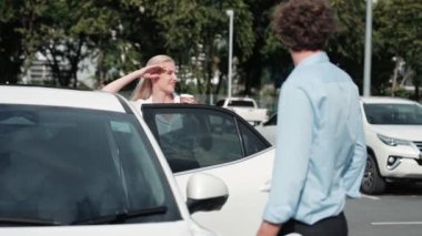 İlerici iş adamı ve iş kadını şehir merkezinde dolaşmadan önce şarj istasyonuna bağlı elektrikli arabaya yaslanıyor. Çevre dostu şarj edilebilir araba temiz enerjiyle çalışıyor..