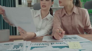 Ofis çalışma alanında birlikte çalışan iki genç hevesli iş kadını. Genç meslektaşlar tartışırken ve dizüstü bilgisayar kullanırken. Modern ofis çalışanları masada birlikte oturuyorlar..