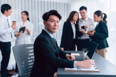 Portrait of focus young successful confident male manager, executive wearing business wear in harmony office arm crossed with blurred meeting background of colleagues, office worker.