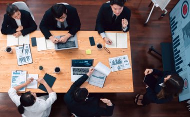 Top view manager or office worker give presentation in harmony conference room to business colleague, BI data dashboard on screen and pile of financial analyzed data reports on meeting table.