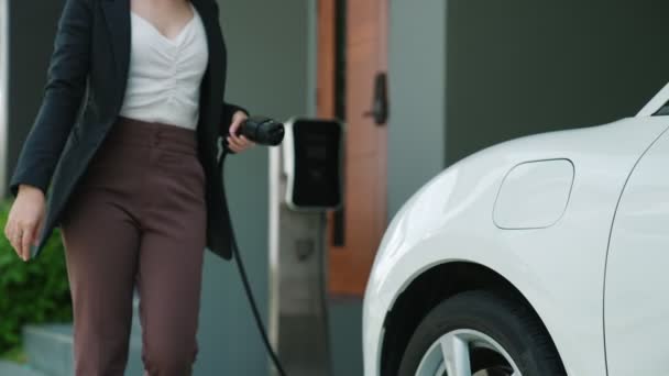 Postępowa Kobieta Instaluje Wtyczkę Stacji Ładowania Swoim Samochodzie Elektrycznym Domu — Wideo stockowe