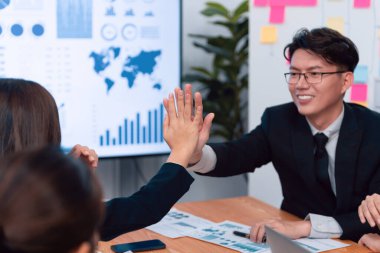 Happy business team office worker making high five with each other and celebrate after successful meeting in office workplace, business agreement to promote harmony and strong teamwork concept.