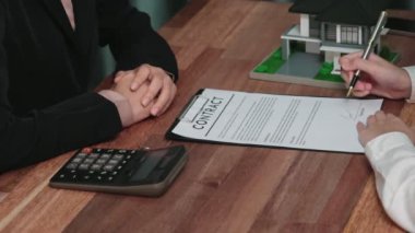 İş kadını ofiste başarılı bir iş anlaşması yaptıktan sonra sözleşme imzaladı. Hevesli müşteri el yazısı resmi kredi, gayrimenkul veya yatırım sözleşmesi belgesine imza atıyor.