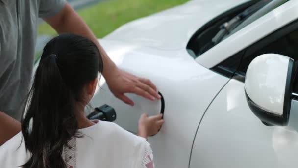 Postępowy Ojciec Córka Instalujący Wtyczkę Stacji Ładowania Domowego Pojazdu Elektrycznego — Wideo stockowe
