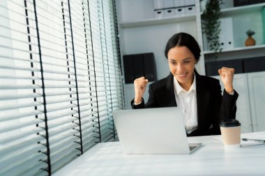 This photo depicts a young African American and competent woman at her workplace. A female employee in her office at work.