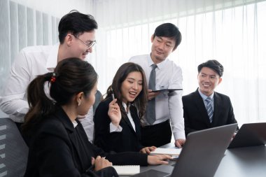 Harmony in office concept as business people analyzing dashboard paper together in workplace. Young colleagues give ideas at manager desk for discussion or strategy planning about project.