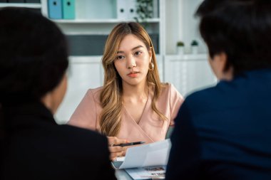 A young female asian candidate tries to impress her interviewer by being competent. International company, multicultural environment in workplace.