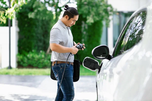 Progressive Asian Man Install Cable Plug His Electric Car Home — Φωτογραφία Αρχείου
