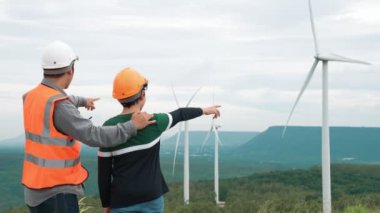 Oğluyla birlikte kırsal kesimdeki bir tepenin tepesinde ya da dağda bir rüzgar çiftliğinde mühendis. Yenilenebilir ve sürdürülebilir enerjinin gelecekteki üretimi için yenilikçi bir ideal. Rüzgar türbininden enerji üretimi.