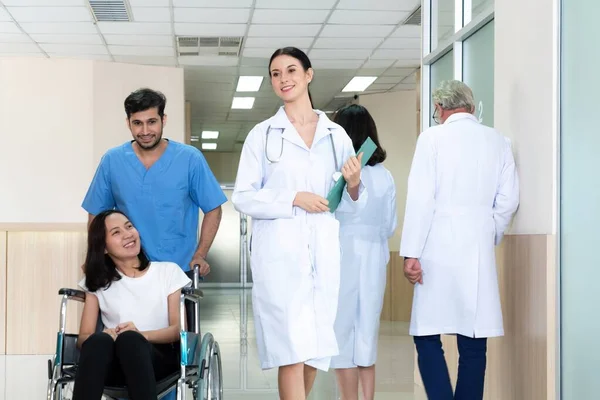 Lekarz Pielęgniarz Przewożą Pacjentkę Wózku Inwalidzkim Sterylnym Szpitalnym Korytarzem Opieka — Zdjęcie stockowe