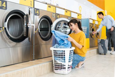 Asyalılar çamaşırlarını yıkamak için halka açık alanda kaliteli para makinelerini kullanıyorlar. Kamu dairesinde ticari çamaşır ve kurutma makinesi kavramı.