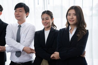 Cohesive group of businesspeople standing in row, holding hand in line together after meeting to promote harmony in workplace. Asian office workers strong teamwork and unity concept.