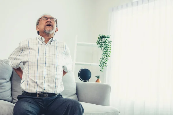 Agonizing Senior Man Need Assistance While Sitting His Sofa Home — Zdjęcie stockowe