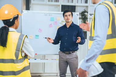 A team of investor and competent engineers brainstorming on the whiteboard to find new ideas and making plans. The idea of a team gather ideas together.