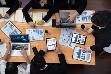 Top-view business team of financial data analysis meeting with business intelligence, report paper and dashboard on laptop for marketing strategy. Business people working together in office of harmony