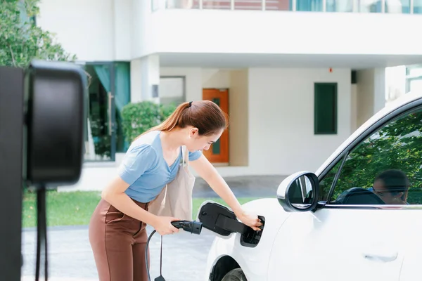Progressive Woman Install Cable Plug Her Electric Car Home Charging — Zdjęcie stockowe