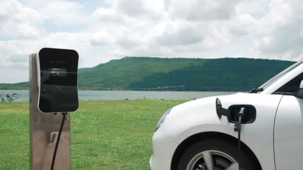 Progressivt Koncept Elektrisk Køretøj Bil Sammen Med Ladestation Naturlig Baggrund – Stock-video