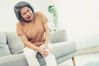 An agonizing elderly woman is experiencing chest pain. Medical attention, medical service for seniors.