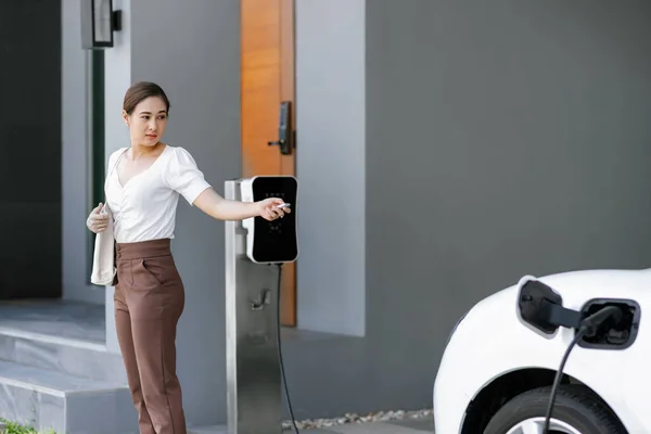 Asyalı Bir Kadın Garajında Uzaktan Kumandalı Araba Anahtarıyla Elektrikli Arabayı — Stok fotoğraf