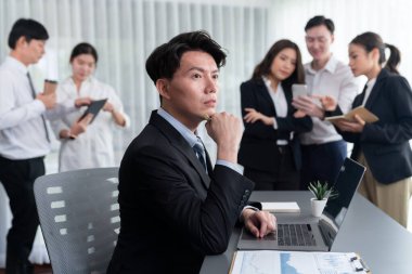 Portrait of focus young successful confident male manager, executive wearing business wear in harmony office arm crossed with blurred meeting background of colleagues, office worker.