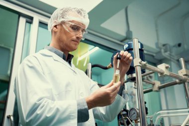 Bir bilim adamı ya da eczacı CBD kenevir yağını laboratuarda tıbbi amaçlar için çıkartıyor. Esrar çıkarma makinesinden üretilen alternatif esrar temelli ilaçlar.