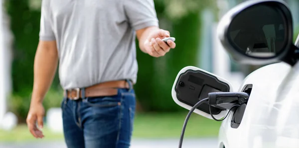 Progressive Asian Man Install Cable Plug His Electric Car Home — Stok fotoğraf