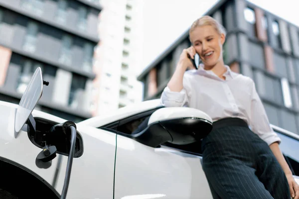Focus Charging Electric Car Charger Charging Station Blur Businesswoman Talking — Stok fotoğraf