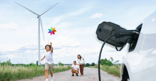 Концепція Прогресивної Щасливої Сім Тримає Вітряну Іграшку Відпочиває Вітроелектростанції Електромобілем — стокове фото