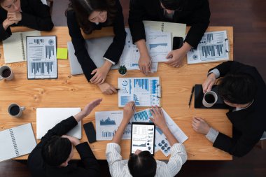 Top-view business team of financial data analysis meeting with business intelligence, report paper and dashboard on laptop for marketing strategy. Business people working together in office of harmony
