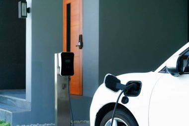 Yeşil çevre için sıfır CO2 emisyonu olan sürdürülebilir ve temiz enerjiyle çalışan EV araba ve ev şarj istasyonu konsepti. Elektrikli taşıtlar için konut alanındaki şarj noktası.