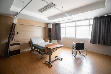 Rahatlatıcı modern hasta yatağı ile donatılmış steril tedavi odası. Hastanenin yatak odası ya da koğuşunun fotoğrafı..