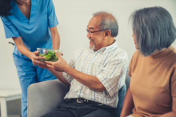Female Nurse Serves Bowl Salad Contented Senior Couple Health Care —  Fotos de Stock