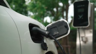 Elektrikli araba parkı ve şarj istasyonunun yanında şarj edilen enerji konseptinin sürdürülebilirliği. Çevresel koruma için yenilenebilir enerji tarafından kullanılan elektrikli araç.