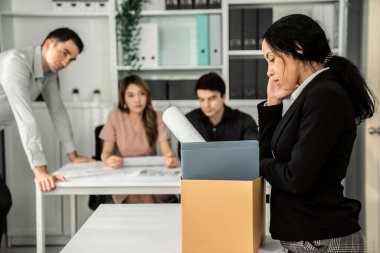 Depressed and disappointed employee packing her belongings after being fired for not being competent. Gossiped by her colleagues behind his back. Layoff due to economic depression.