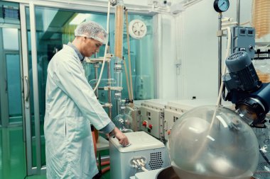 Kimyasal süreçleri kullanarak esrar, CBD yağı ve tentürleri çıkaran bir kimyager ya da eczacı. Tıbbi kenevir üretim tesisi. Kenevir yağı çıkarma makinesi ve ekipmanı.