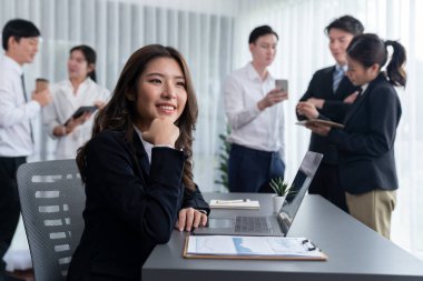 Focus portrait of female manger, businesswoman in the harmony meeting room with blurred of colleagues working together, analyzing financial paper report and dashboard data in background.