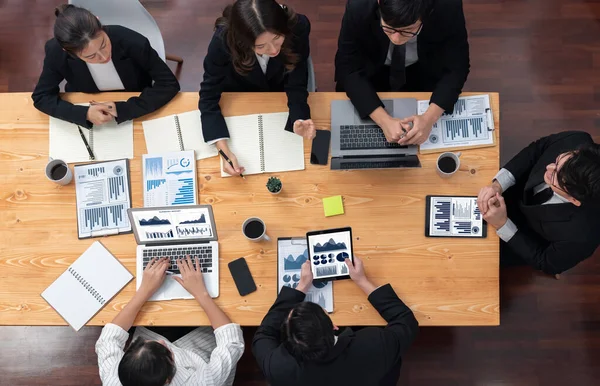 Top-view business team of financial data analysis meeting with business intelligence, report paper and dashboard on laptop for marketing strategy. Business people working together in office of harmony