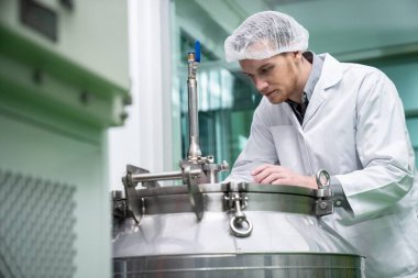 Bir bilim adamının portresi, eczacı laboratuarda bilimsel ekipman kullanarak kenevir yağı çıkarıyor. Alternatif tıbbi tedavi için esrar çıkarma kavramı