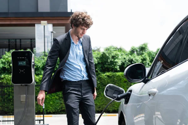 Progressive Businessman Wearing Black Suit Electric Car Recharging Public Parking — Stock Fotó