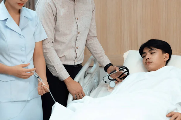 의사와 간호사가 병원의 환자를 치료하기 주사하고 주사를 튜브에 넣는다 환자는 — 스톡 사진