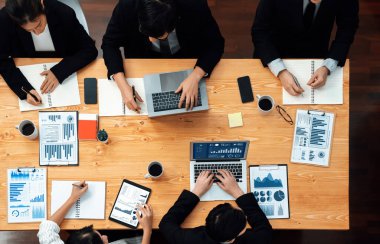 Top-view business team of financial data analysis meeting with business intelligence, report paper and dashboard on laptop for marketing strategy. Business people working together in office of harmony