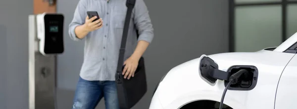 Progressive Asian Man Electric Car Home Charging Station Concept Use — 스톡 사진