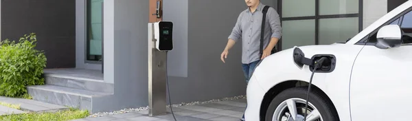 Progressive Asian Man Electric Car Home Charging Station Concept Use — Φωτογραφία Αρχείου